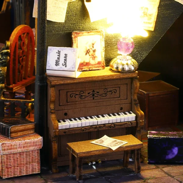 Close-up of the sorceress' magic piano inside the Luna Magic House miniature dollhouse, with a lamp and music scores on top.