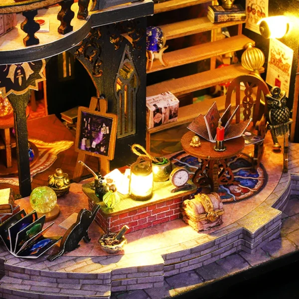 Close-up of the workbench inside the Luna Magic House miniature dollhouse, featuring spell books, lanterns, and magical artifacts.