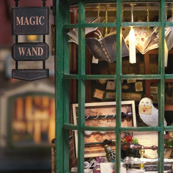 Close-up of the window display at the Magic Wand Shop Miniature Dollhouse Kit, highlighting detailed books and magical items.