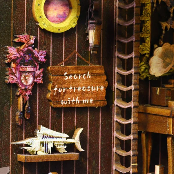 Miniature pirate clock and "Search for treasure with me" sign inside the Pirate Ship Aden DIY book nook.