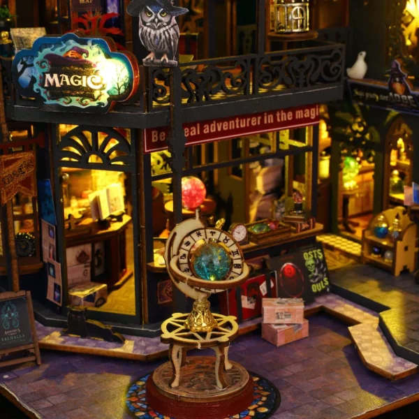 Close-up of the arcane celestial globe, shopfront, and mystical artifacts in the Holo Magic City miniature dollhouse.