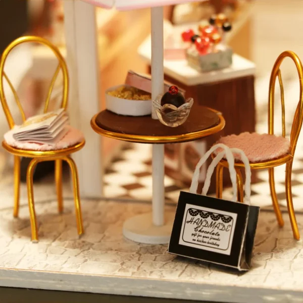 Close-up of outdoor seating with gold chairs, a table with chocolates, and a handmade chocolate gift bag at the Cocoa Fantasy chocolate shop.