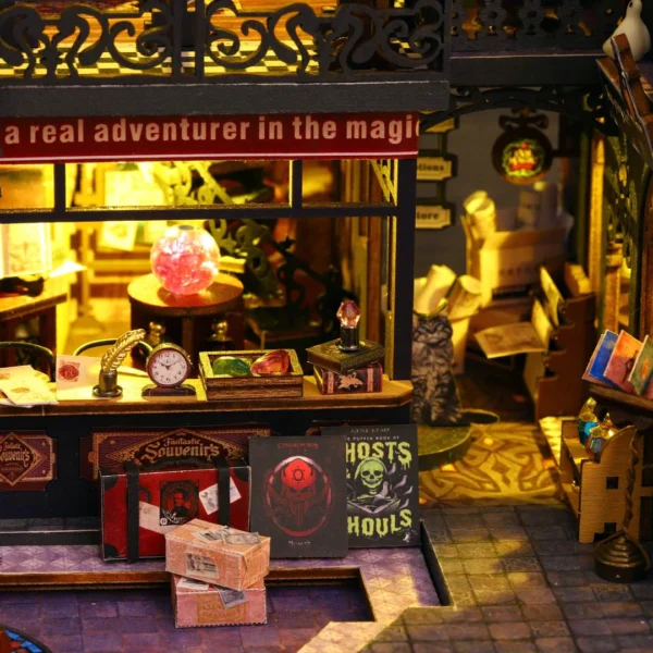 Close-up of a magical shop display featuring books, crystals, and artifacts, illuminated by warm golden light in the Holo Magic City DIY miniature dollhouse kit.