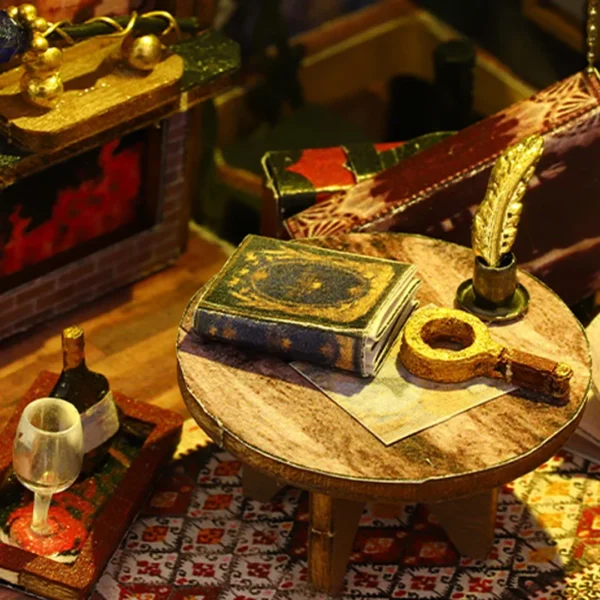 Close-up of a table in Holo Magic City miniature dollhouse featuring an enchanted book, a golden key, a quill, and a glass of wine.