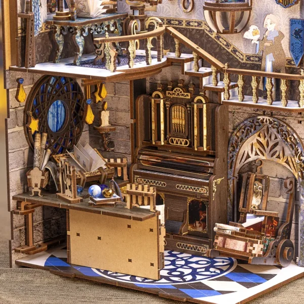 Close-up of the Nebula Rest Room book nook, showcasing the detailed craftsmanship of the magical organ, the workbench with potions, and a luggage cart with suitcases and a birdcage holding a cute owl.