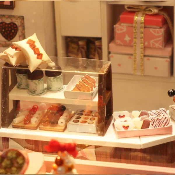 Close-up view of a glass display case inside the Cocoa Fantasy shop, featuring miniature desserts, chocolates, and packaged treats.