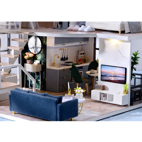 Close-up of the living room and kitchen in the Cozy Time DIY miniature dollhouse, featuring a dark blue velvet sofa, a white coffee table, and a modern kitchen with gold-accented fixtures.