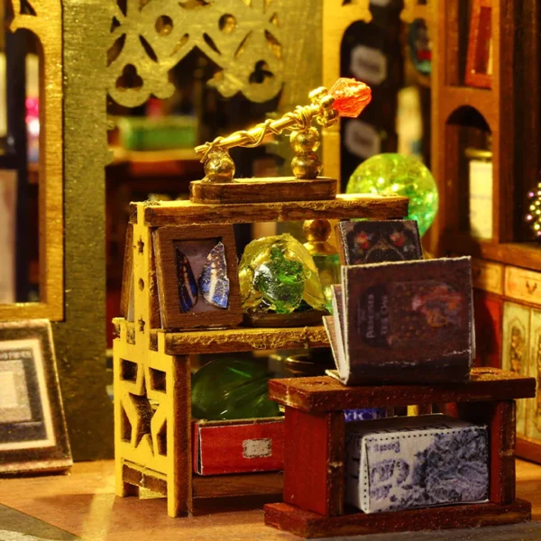 Close-up of a magic shop window displaying a glowing crystal ball, books, and magical artifacts in the Holo Magic City miniature dollhouse kit.