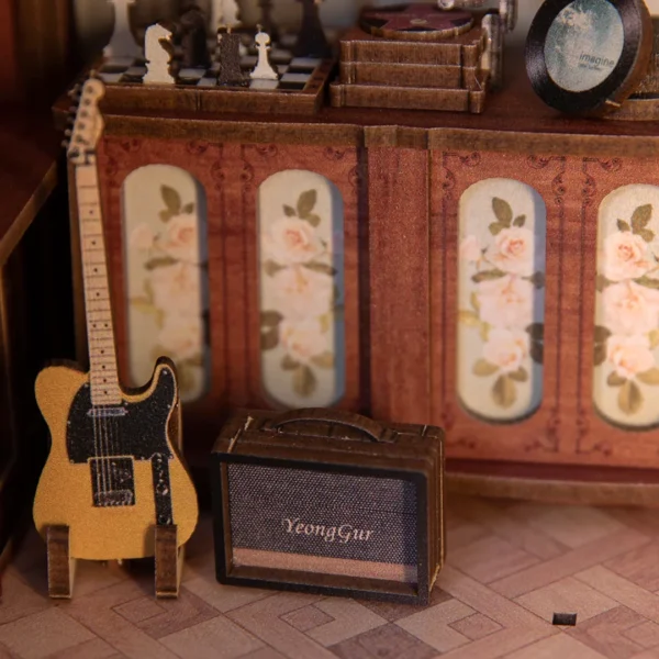 Close-up of a guitar and amplifier in The Secret Rhythm book nook, featuring a vintage design with a chess set and vinyl records in the background.