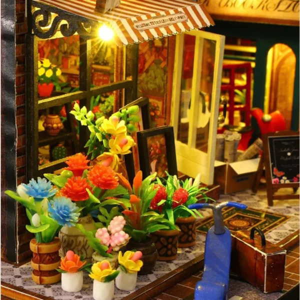 Close-up of flower shop entrance at Scarbrough Hotel DIY miniature dollhouse with vibrant potted plants and cozy decor.