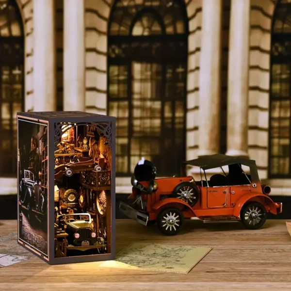 A close-up view of the Car Players book nook, showcasing a retro vehicle showroom with a black pickup truck, a red Formula One car, and a Harley motorcycle, surrounded by vintage tools and memorabilia.